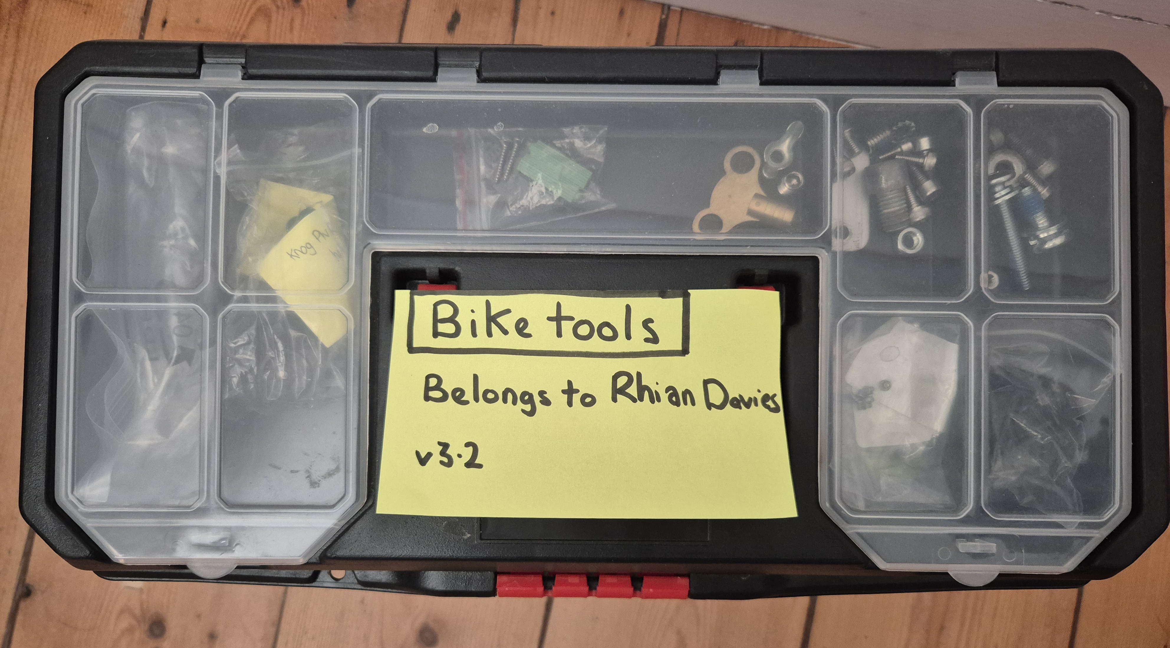The lid of a toolbox with a label on it, describing that the box contains bike tools. The label also says who the toolbox belongs to and featues a version number.