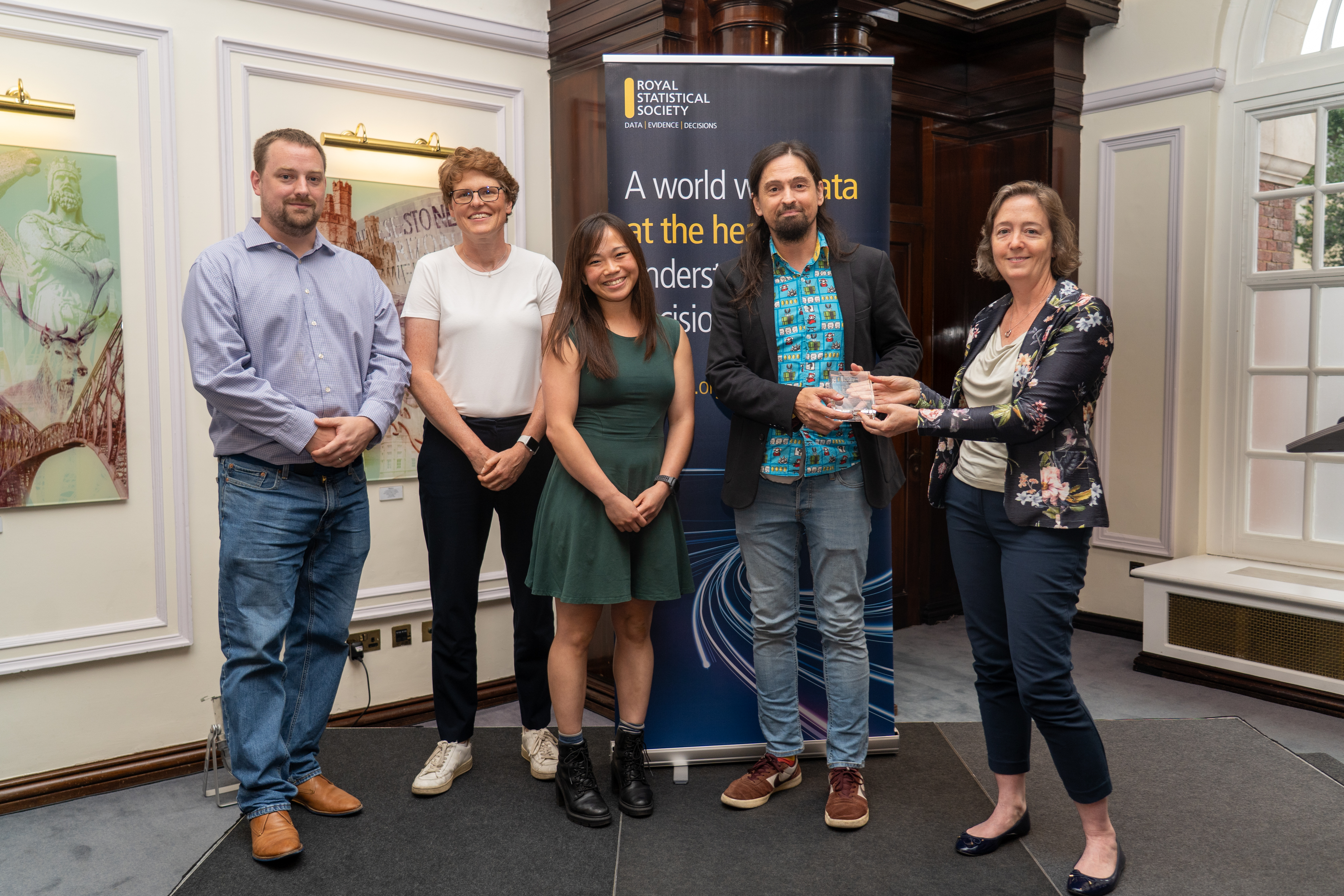 Four members of our team recieving the Florence Nightingale award. In front of an RSS banner